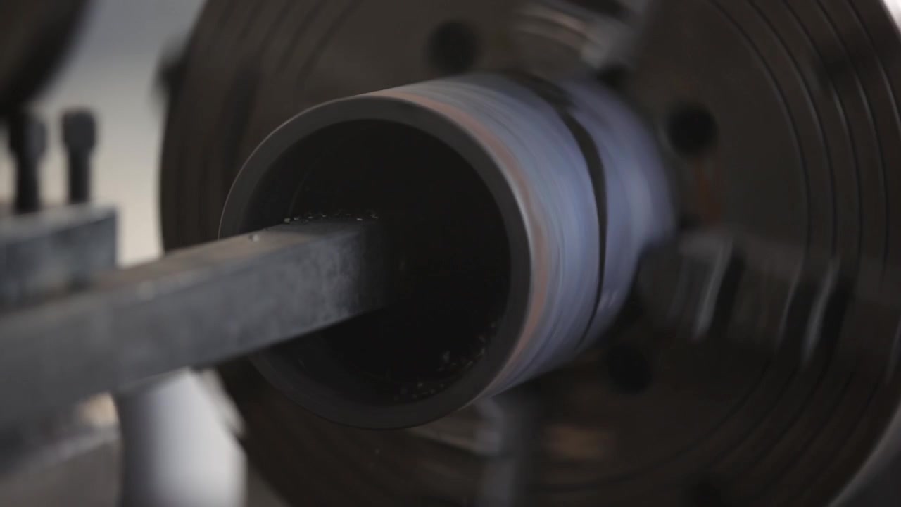 Nahaufnahme einer weißen Fabrikfassadenwand mit gewölbter Dachlinie und seitlichen Lüftungsfenstern
