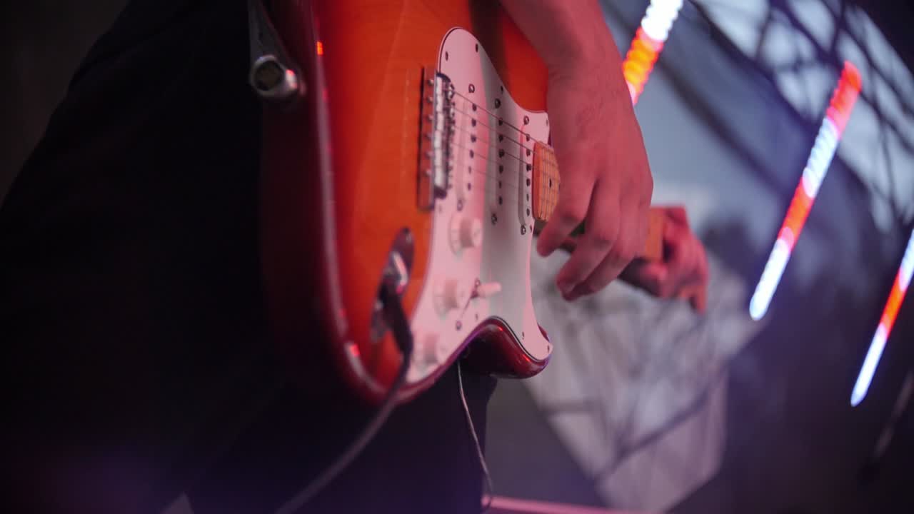 Mand spiller elektrisk guitar på scene til rockkoncert
