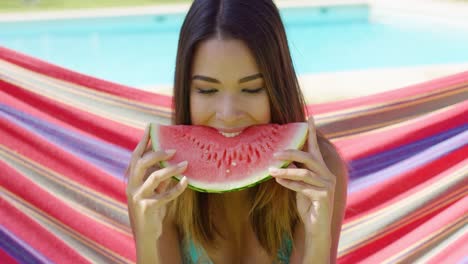 smiling young woman holding one watermelon slice