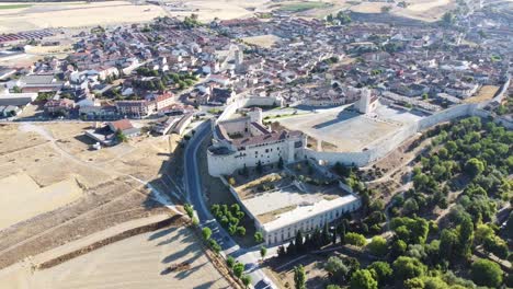 Vista-Aérea-Del-Castillo-O-Palacio-Medieval-A-La-Luz-Del-Día-Con-Paredes-Largas,-Jardín-Y-Casco-Antiguo-Tradicional