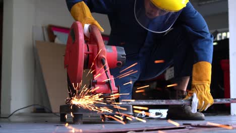 professional mechanic is cutting steel metal.