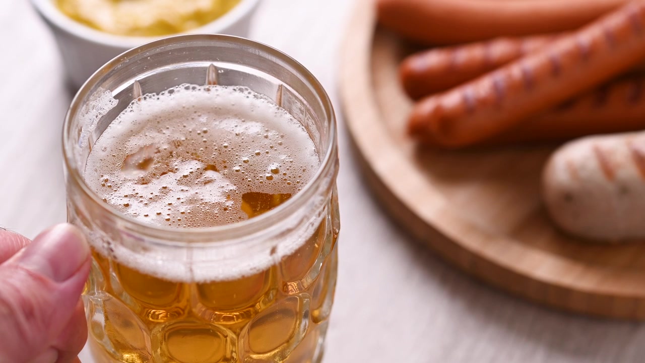 Mano che prende un boccale di birra dal tavolo all'Oktoberfest