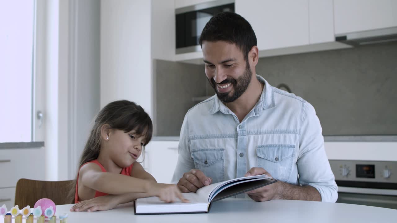 papá ayudando a su hija a aprender a leer