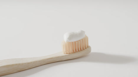 close up of toothbrush with toothpaste on white background with copy space