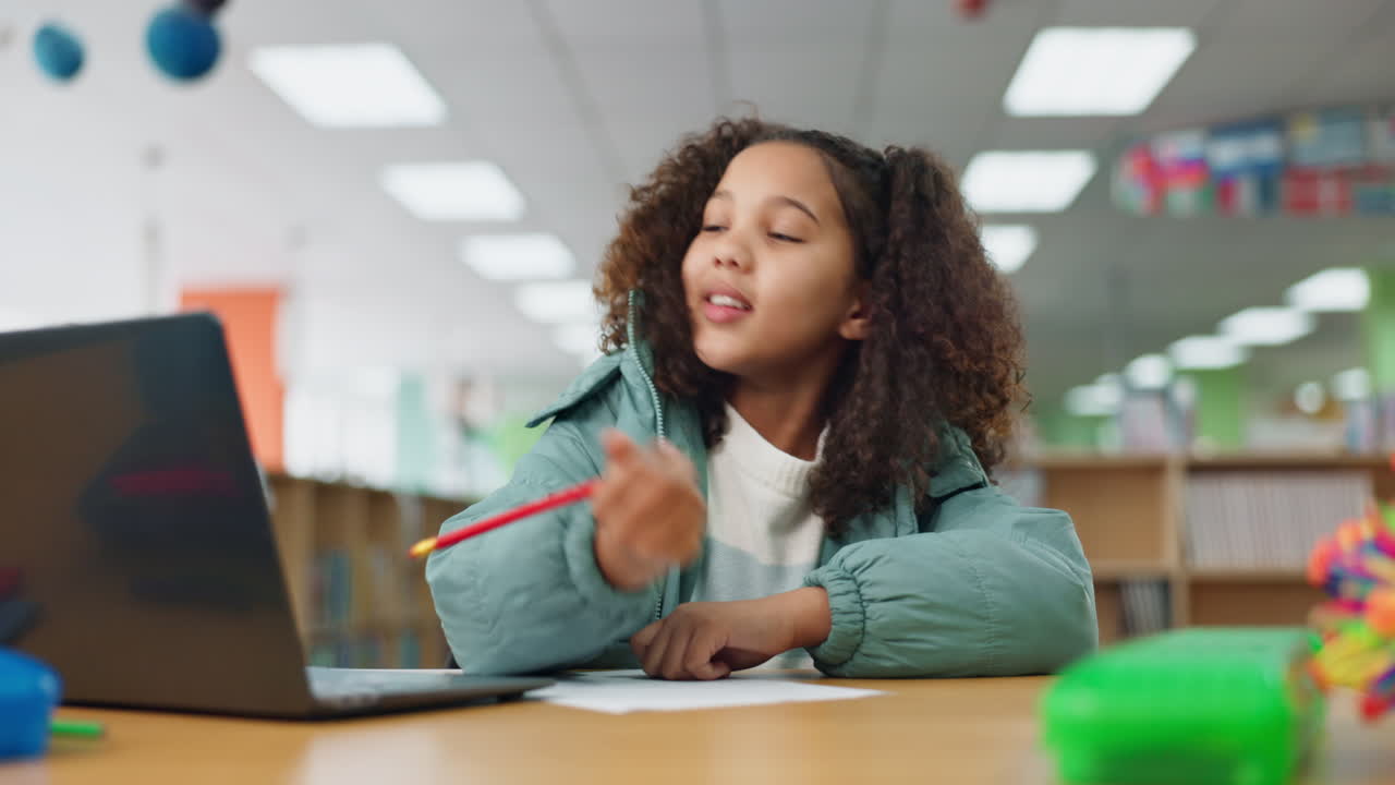 Girl studying with laptop in classroom