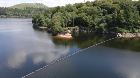 aerial pan over placid surface of burrator reservoir in dartmoor national park