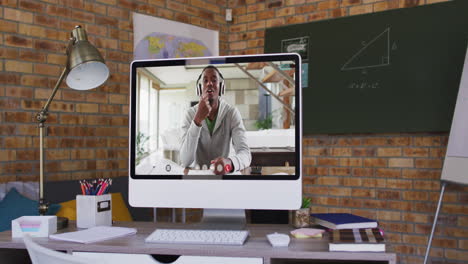 webcam view of african american male college student on video call on computer on table at school