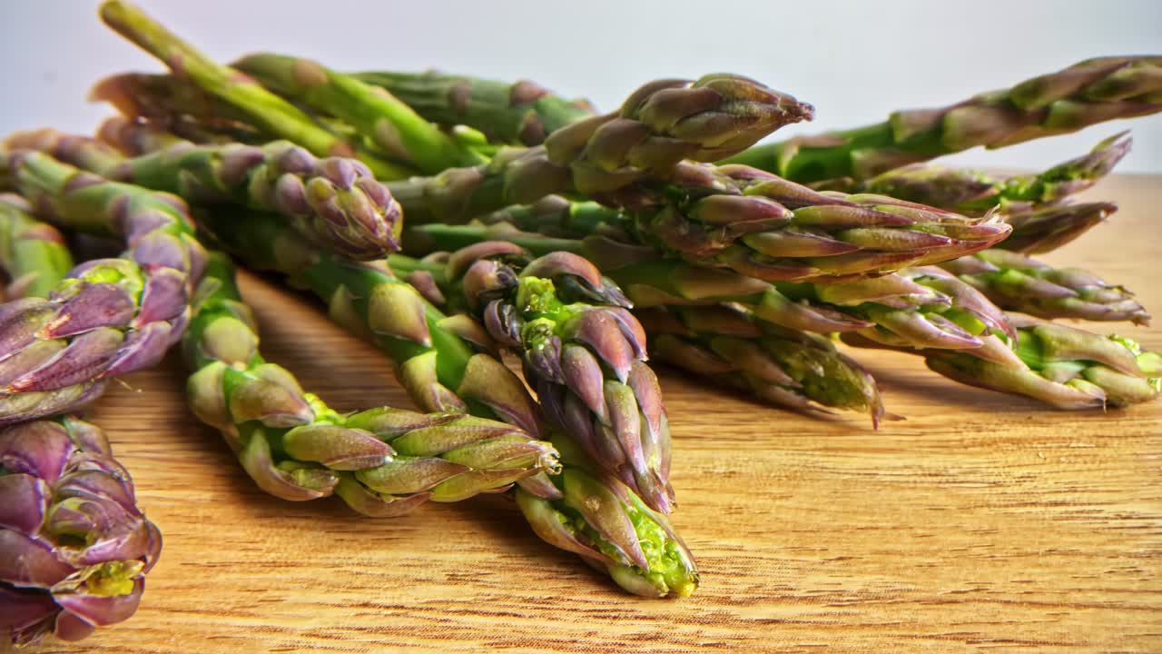 Fresh Raw Asparagus Laid Out on Wooden Table With Natural Light in Slider shot