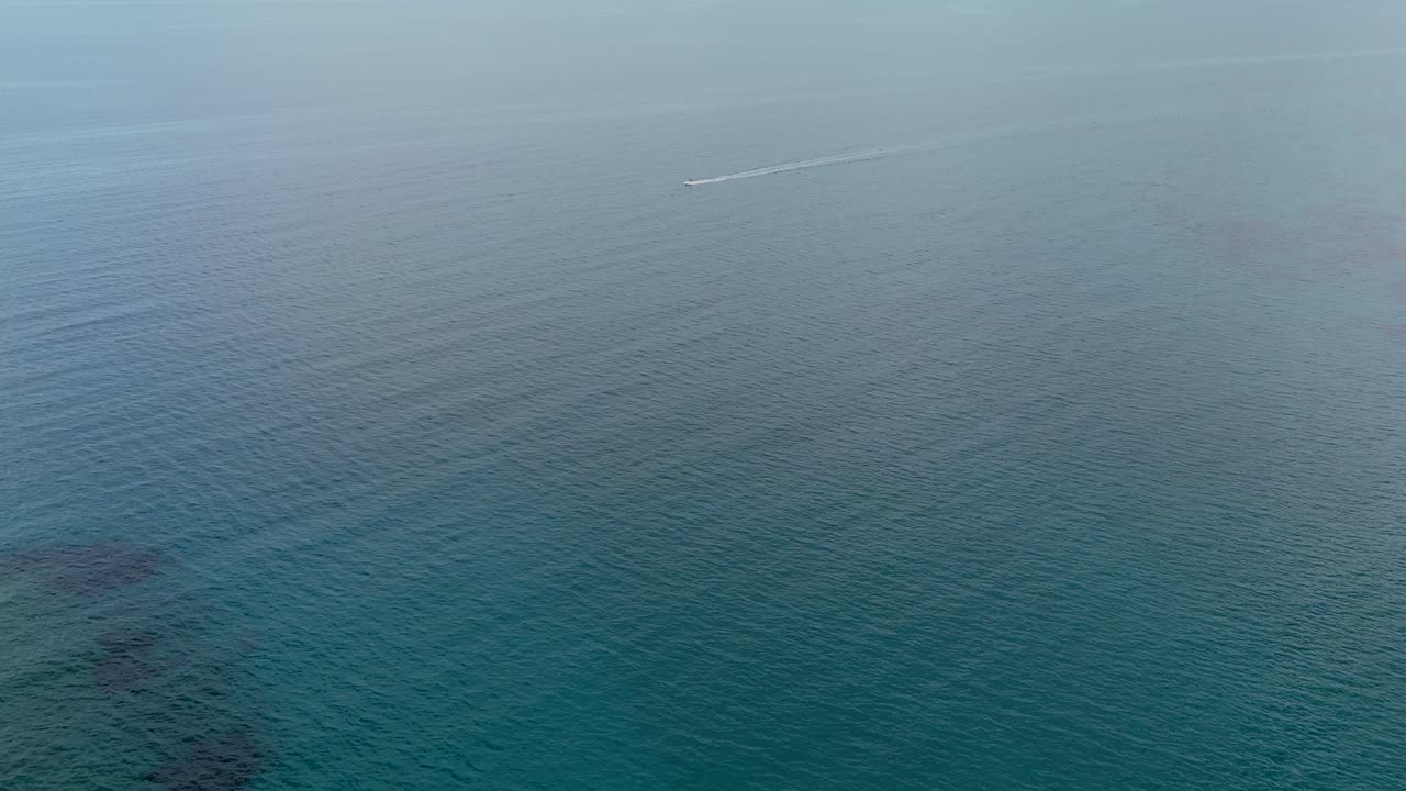 Aerial - fast-moving boat on open blue sea off the coast of Crete Greece
