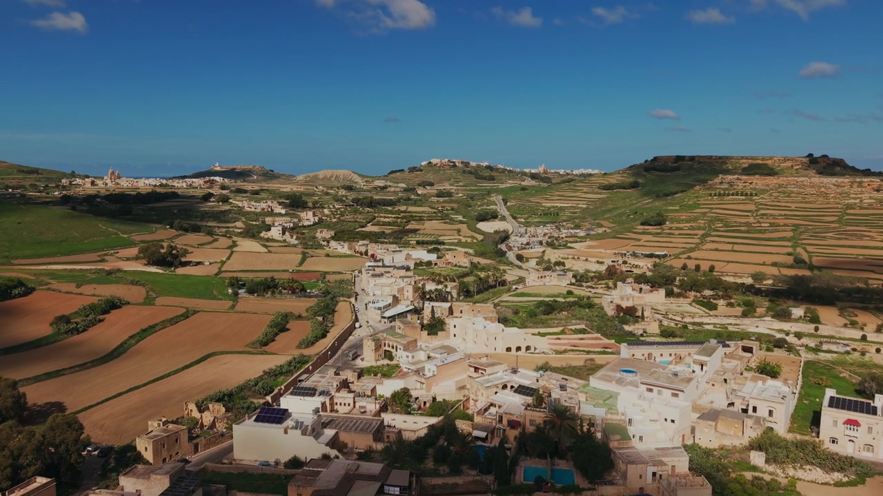 Ripresa con drone di un villaggio rurale e campi terrazzati sotto un cielo blu