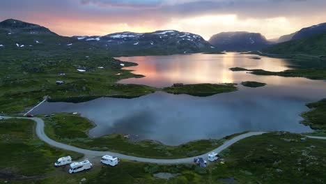 rv camper motorhomes wildcamping at the water during sunset in norway - aerial circling