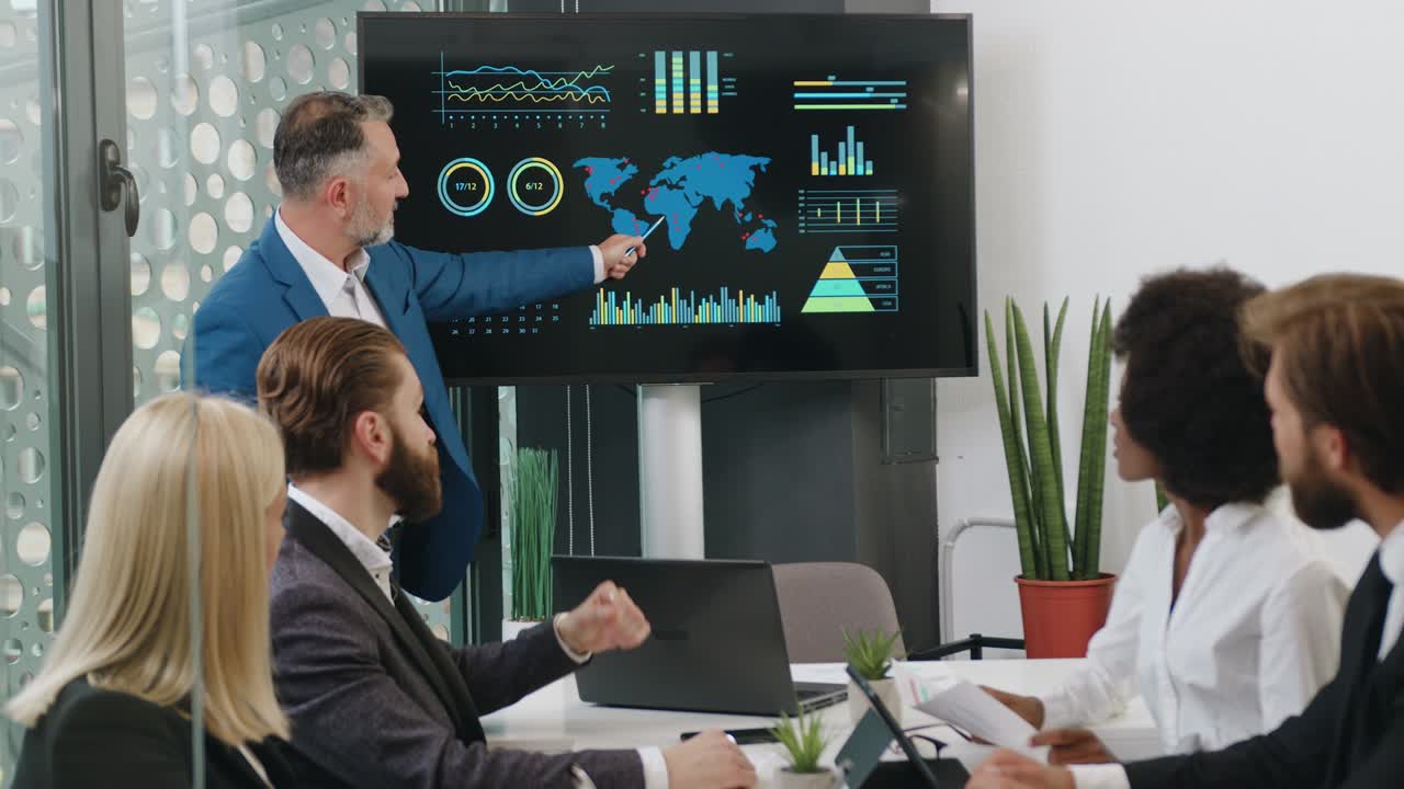 Good-looking confident attantive mixed race people listening their bearded chief which showing dynamics of ecological problems of planet using digital whiteboard
