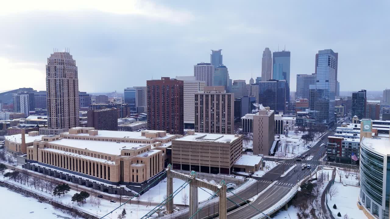 Minneapolis şehir merkezinin silüeti, kuşbakışı karla kaplı caddelerin ve tarihi binaların üzerinde yükseliyor