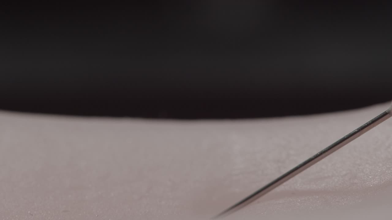 백신이나 의료 주사를 받는 환자의 피부를 관통하는 주사기의 거시적 관점