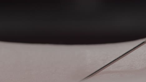 macro view of a syringe piercing the skin of a patient receiving a vaccine or medical injection