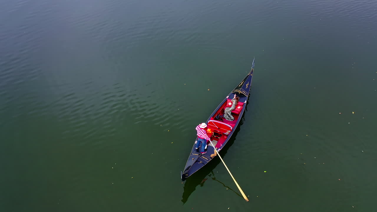 Magic drone shot of gondola. Gondolier take tourists on romantic gondola rides