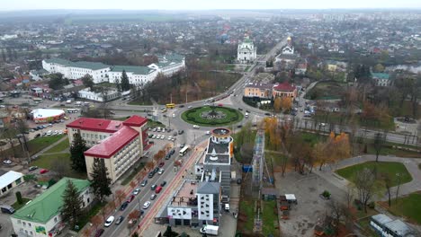 4k aerial view of roundabout road with circular cars in small european city at cloudy autumn day