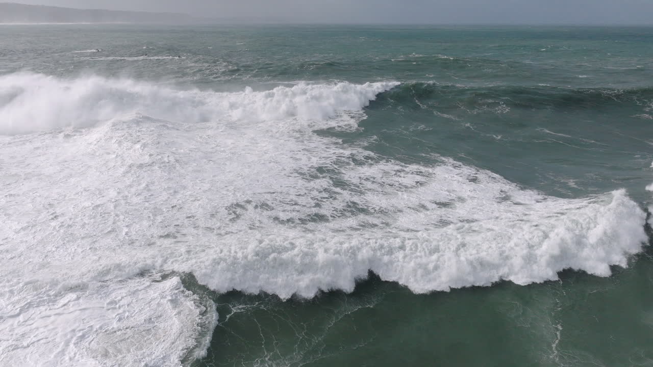 Powerful ocean surges at famous iconic Nazaré aerial drone shot