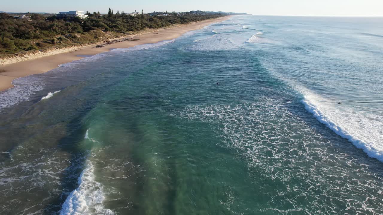 surfistas y olas en la superficie del mar en la playa de coolum en verano