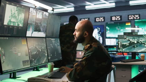 hombre mirando pantallas en la base del cuartel general militar interceptando cohetes balísticos