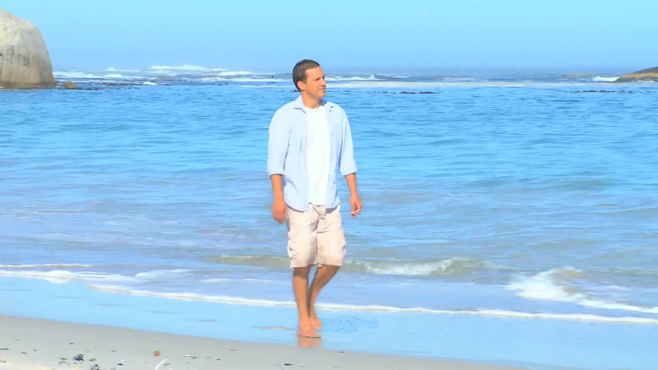 해변 을 따라  ⁇ 고 있는 매력적 인 남자