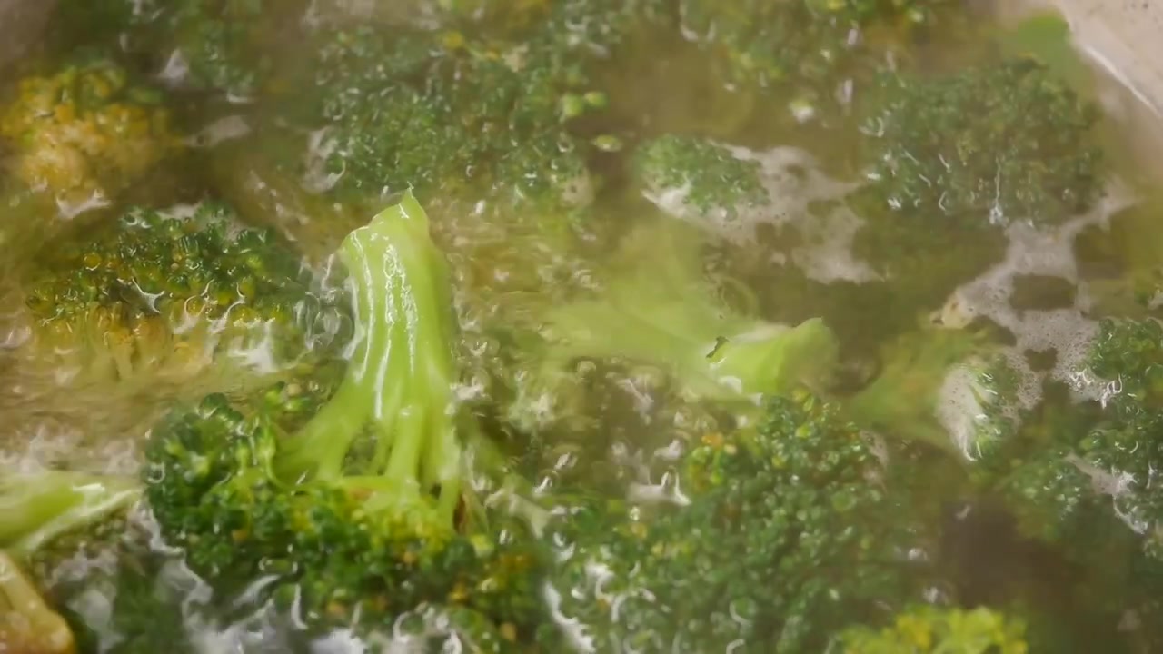 Cimette di broccoli freschi che bollono in una pentola d'acqua