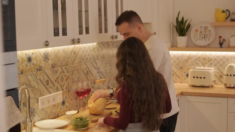 una pareja enamorada haciendo un sándwich en la cocina de la sala de estar