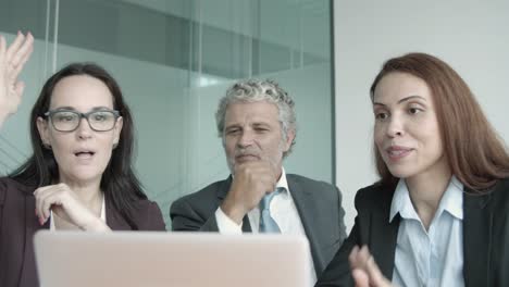 focused businesspeople looking on laptop screen