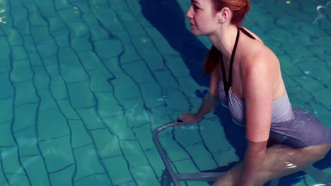 mujer en forma en bicicleta en la piscina