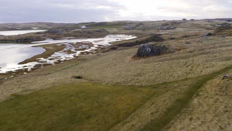 drone shot of a fiddler playing his violin outside by the sea on a country estate on the isle of lewis, outer hebrides of scotland, united kingdom