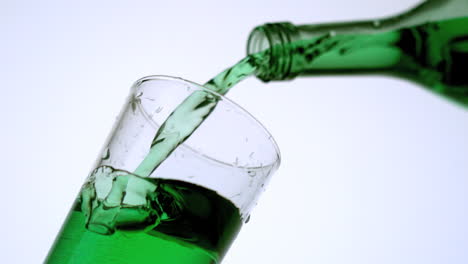 green liquid pouring into glass