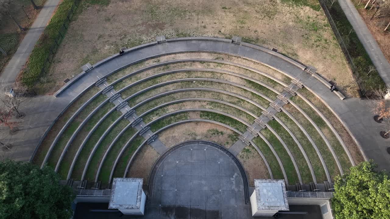 Nashville'deki açık hava amfi tiyatrosunun havadan genel görünümü: kavisli oturma sıraları, merkez sahne, çevresindeki park alanı ve sakin bir gündüz şehir ortamında geometrik tasarım. Yukarıdan aşağıya.