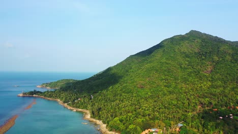 Tropical-rocky-coast-with-exotic-vegetation-on-the-hills,-emerald-calm-lagoon