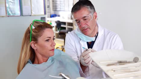 el dentista tranquilizando a su paciente sobre la jeringa.
