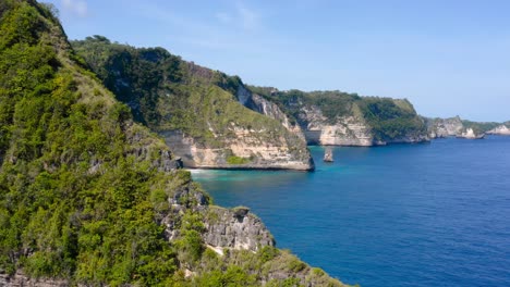 majestic cliffs standing tall beside coastline of beach and low tides moving towards them