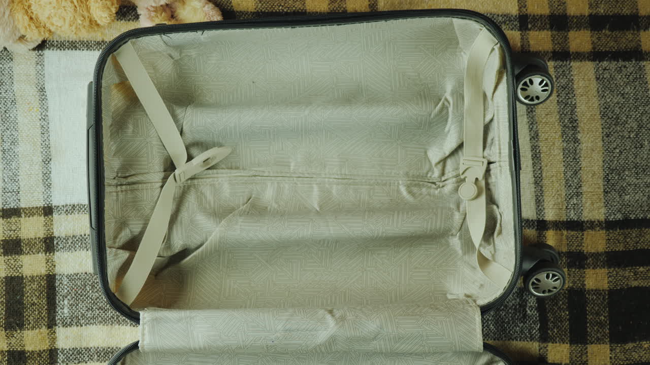 그 아이는 어린이 개념 4k 비디오와 함께 여행하는 여행 가방에 장난감을 넣습니다.