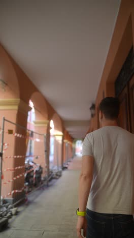 man walking through an urban arcade under construction