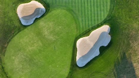 golf course green surrounded by sand bunkers