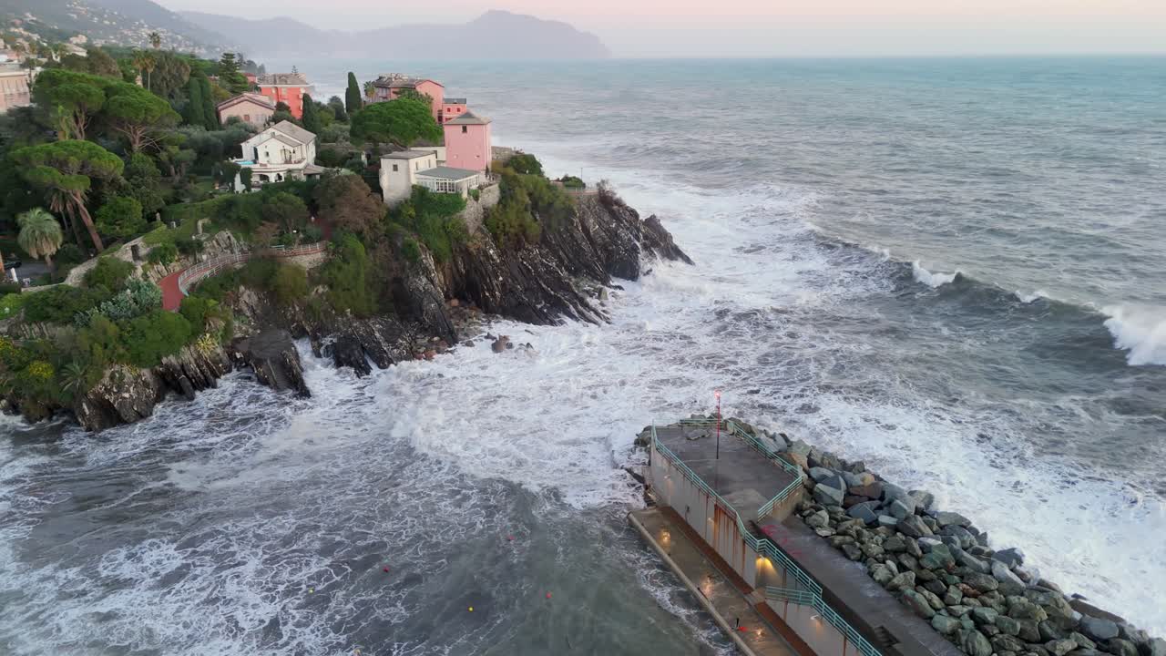 Grandi onde marine spumeggianti che si infrangono in un porto stretto arginato da un frangiflutti.