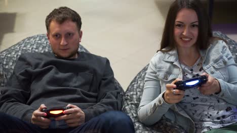 Young-couple-playing-video-game-at-home.-Shooting-and-controlling-using-the-game-controller