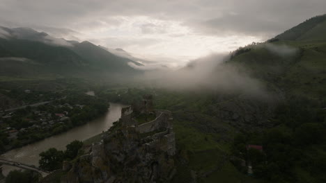 atsquri fortress remnants on the bank of mtkvari river on a foggy day in georgia