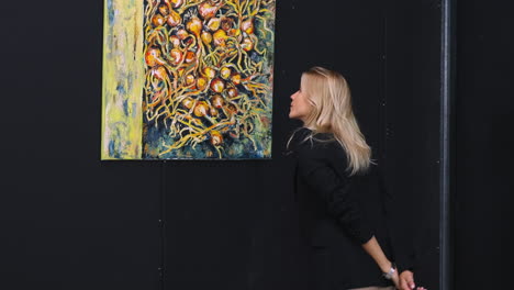 woman viewing an abstract painting of onions in an art gallery