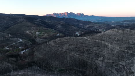 Vista-Aérea-Volando-Sobre-Un-Desastre-Natural-De-Incendios-Forestales-En-La-Ladera-Con-La-Cordillera-Del-Amanecer-En-La-Distancia