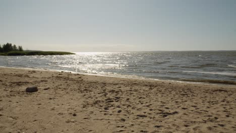 Superficie-Del-Océano-Reluciente-A-La-Luz-Del-Atardecer,-Playa-En-Frombork,-Norte-De-Polonia---Plano-General