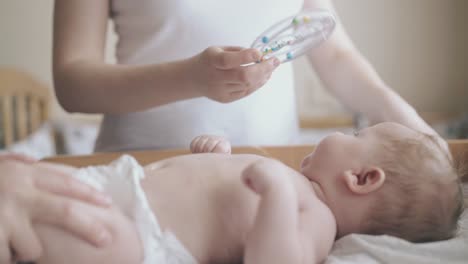 nurse makes infant massage and mother distracts attention