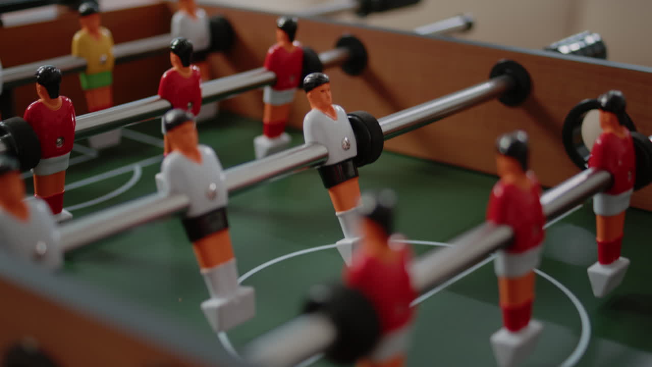 Close up of players on foosball game table for fun activity