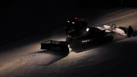 Rasuradora-De-Nieve-Trabajando-De-Noche-En-Los-Dolomitas,-Italia,-Luces-Brillantes-Contra-El-Oscuro-Fondo-Invernal