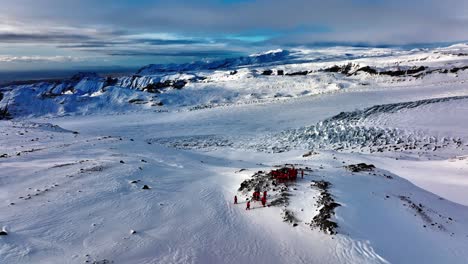 aerial view of people looking at the myrdalsjokull glacier panorama, after riding snowmobiles in iceland, at dusk