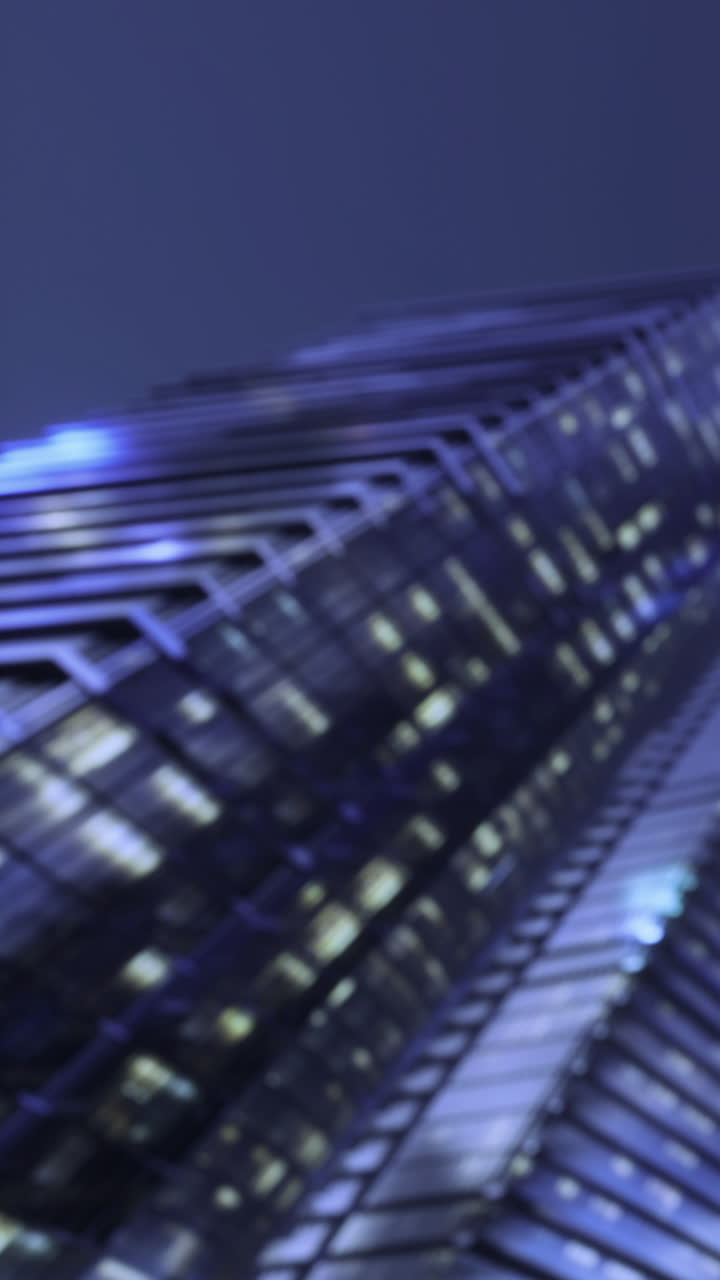 City buildings reflect lights at night under a clear sky