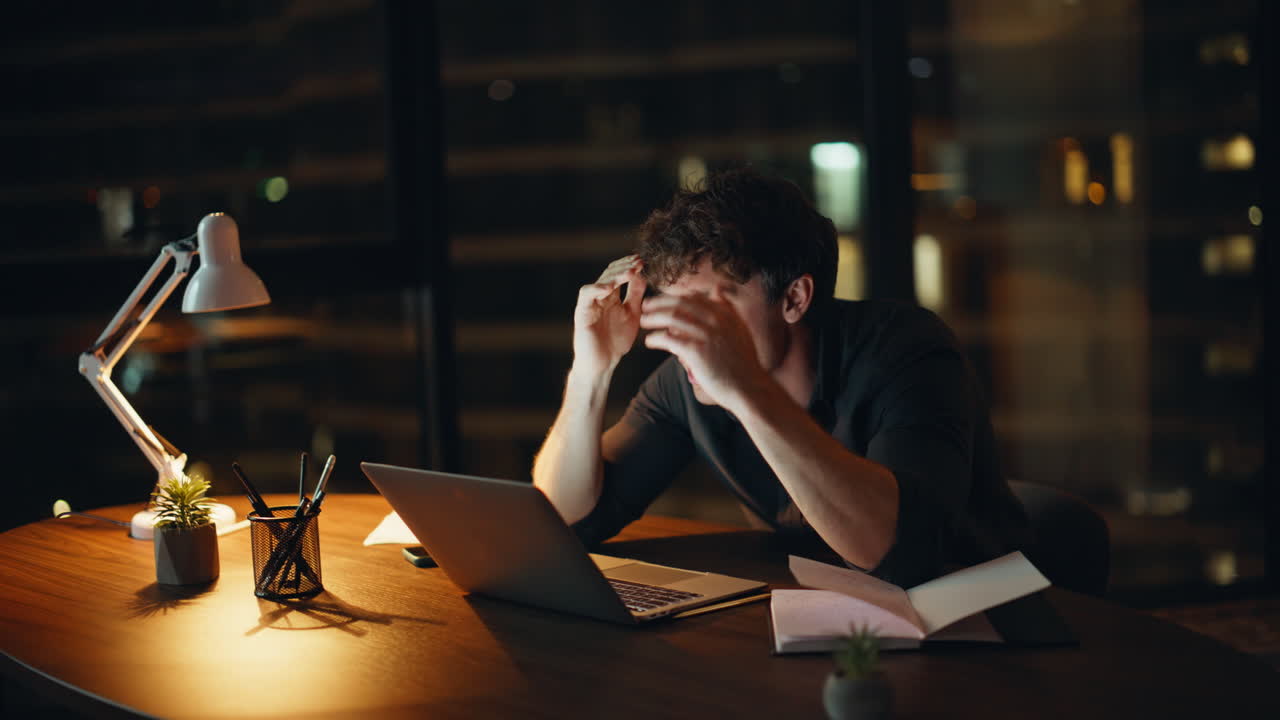 Shocked freelancer losing job reading laptop email at night home closeup